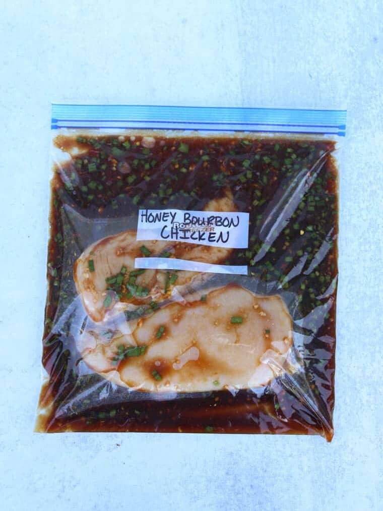 Chicken Breasts in a freezer bag with marinade labeled Honey Bourbon Chicken.