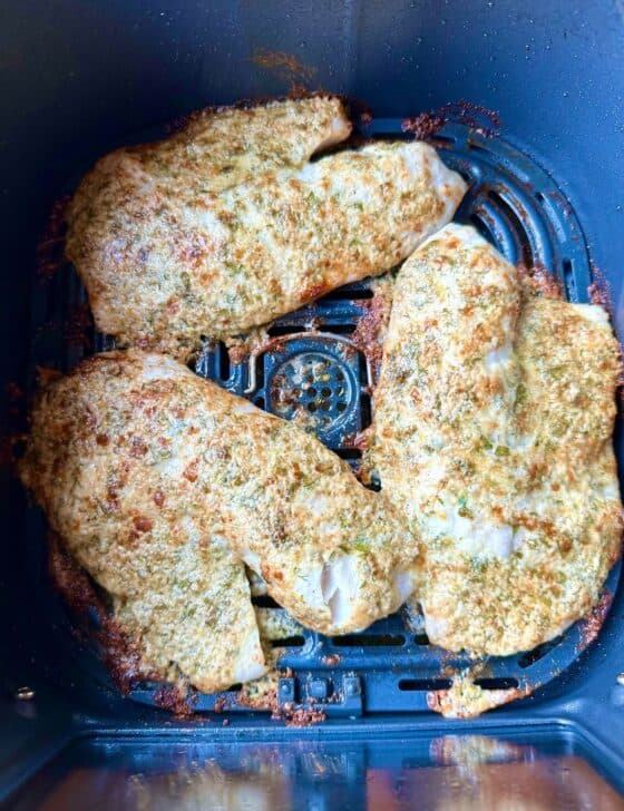 Air fryer tilapia in the air fryer basket after cooking.