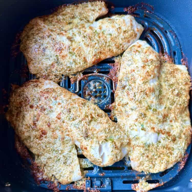 Air fryer tilapia in the air fryer basket after cooking.