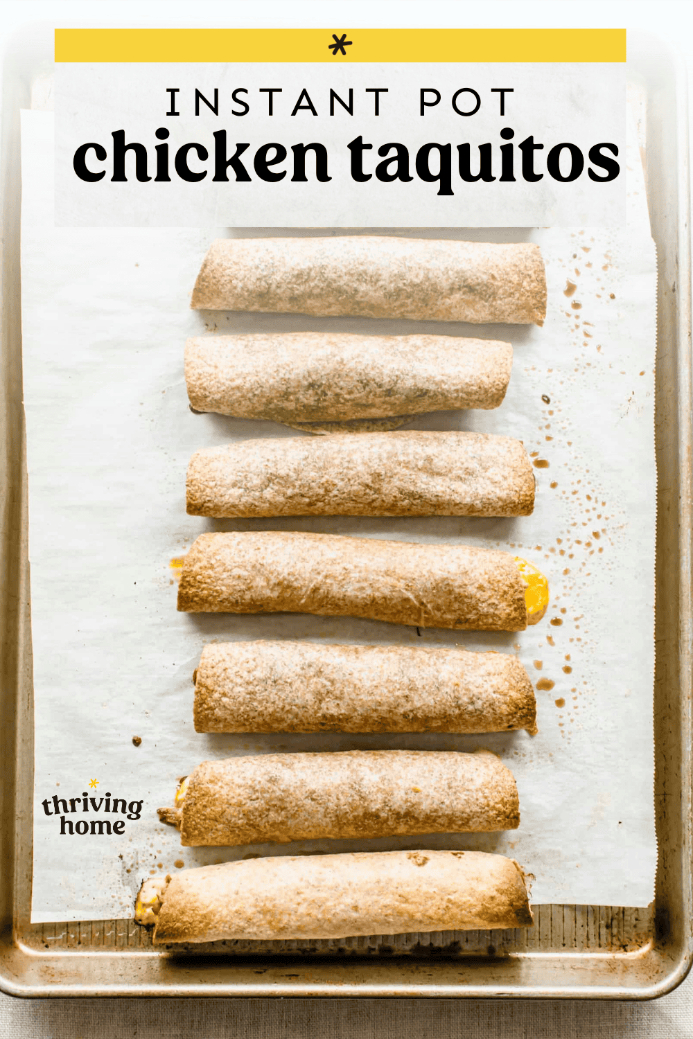 Chicken taquitos lined up on a baking sheet.