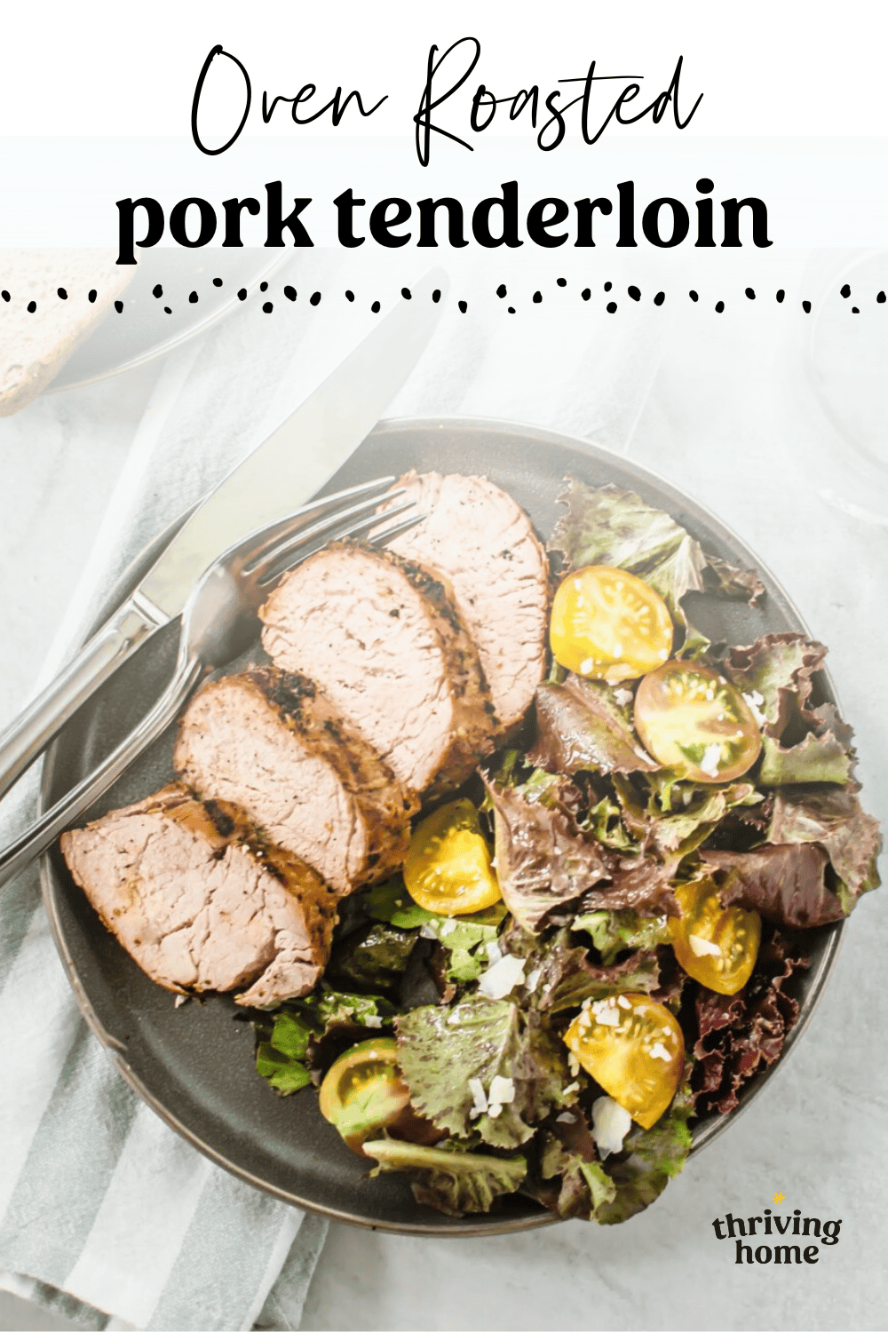 Sliced pork tenderloin on a plate with a side salad.