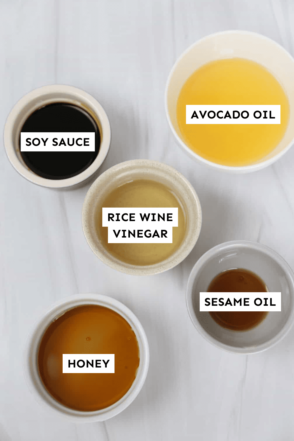 Asian sesame salad dressing ingredients measured out in bowls and labeled.
