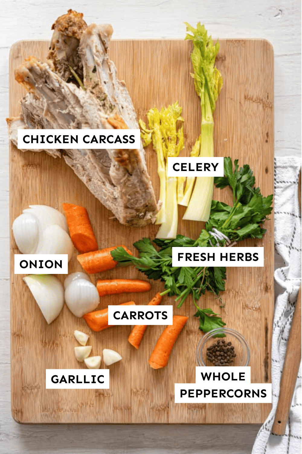 Chicken carcass, onion, carrot, celery, water, and fresh herbs in a pot.