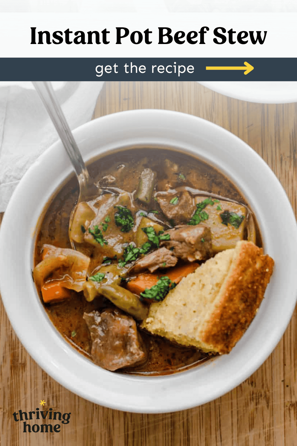 Bowl of Instant Pot beef stew with a piece of cornbread in it.