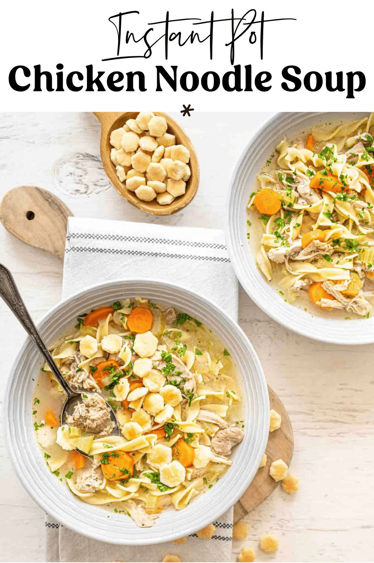 Chicken noodle soup in bowls with a small bowl of oyster crackers in between them.