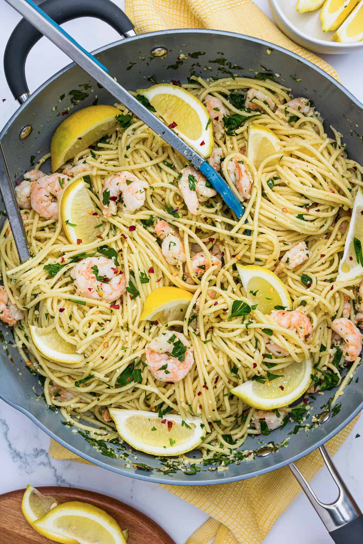Shrimp Scampi Pasta with spaghetti in a pan with tongs.