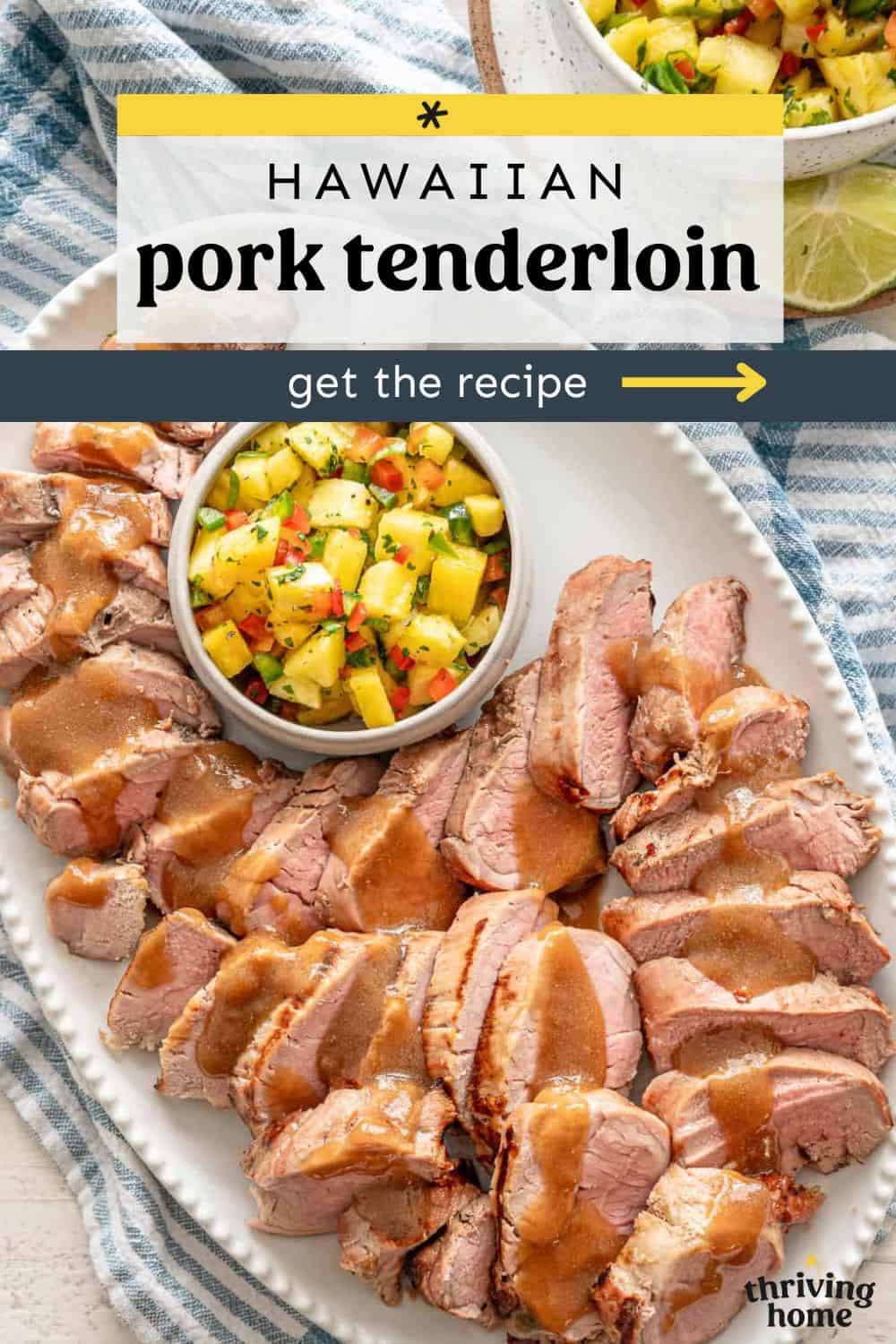 Hawaiian pork tenderloin sliced and served on a platter with a bowl of pineapple salsa.