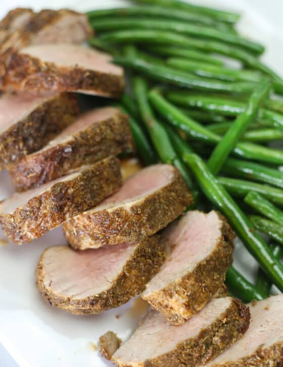 Herb crusted pork tenderloin served with green beans.
