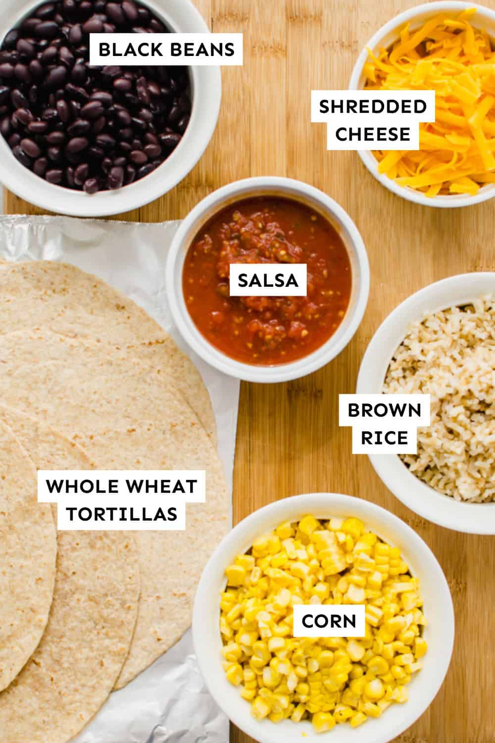 Make-ahead lunch wrap ingredients laid out in bowls and labeled.
