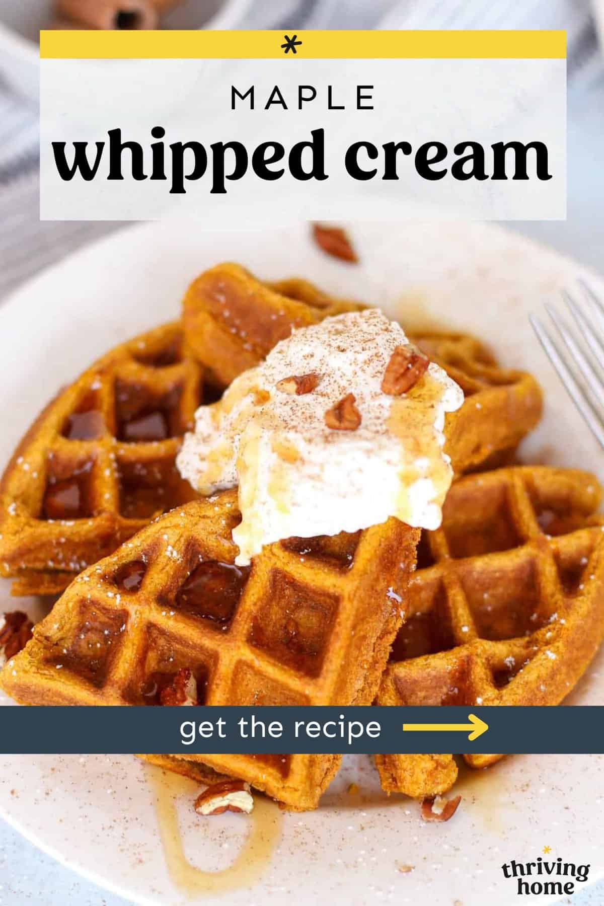 Pumpkin waffles piled up on a plate with a dollop of maple whipped cream and chopped pecans.