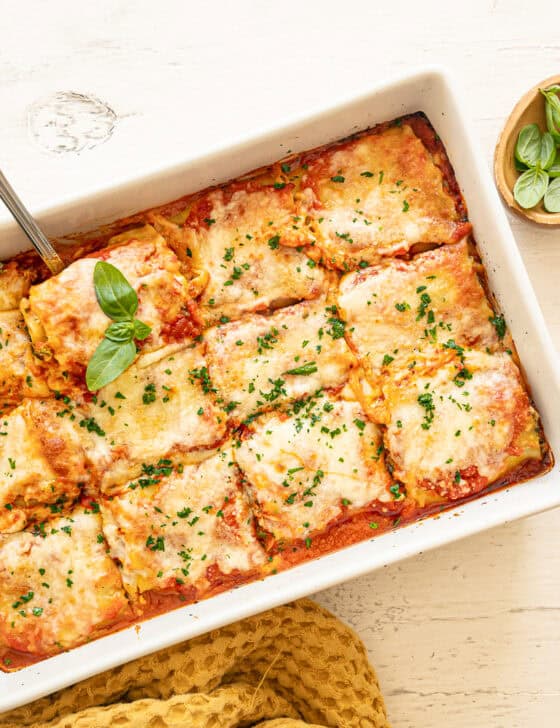 Spinach lasagna rolls out of the oven and cut into individual servings.