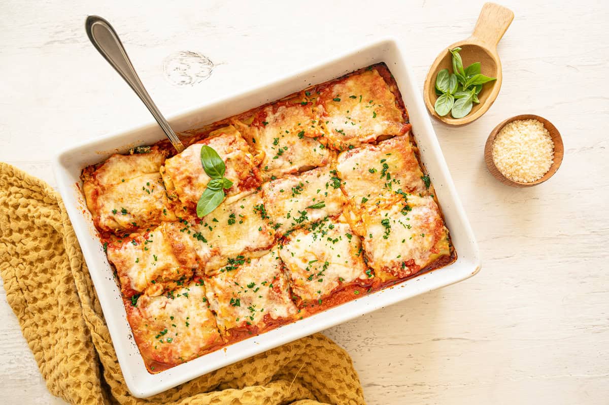 Spinach lasagna rolls out of the oven and cut into individual servings.