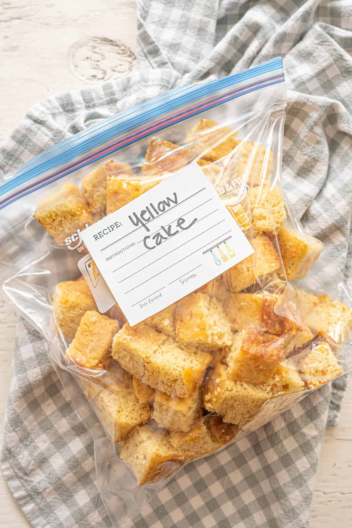 Yellow cake cut into cubes in a freezer bag.