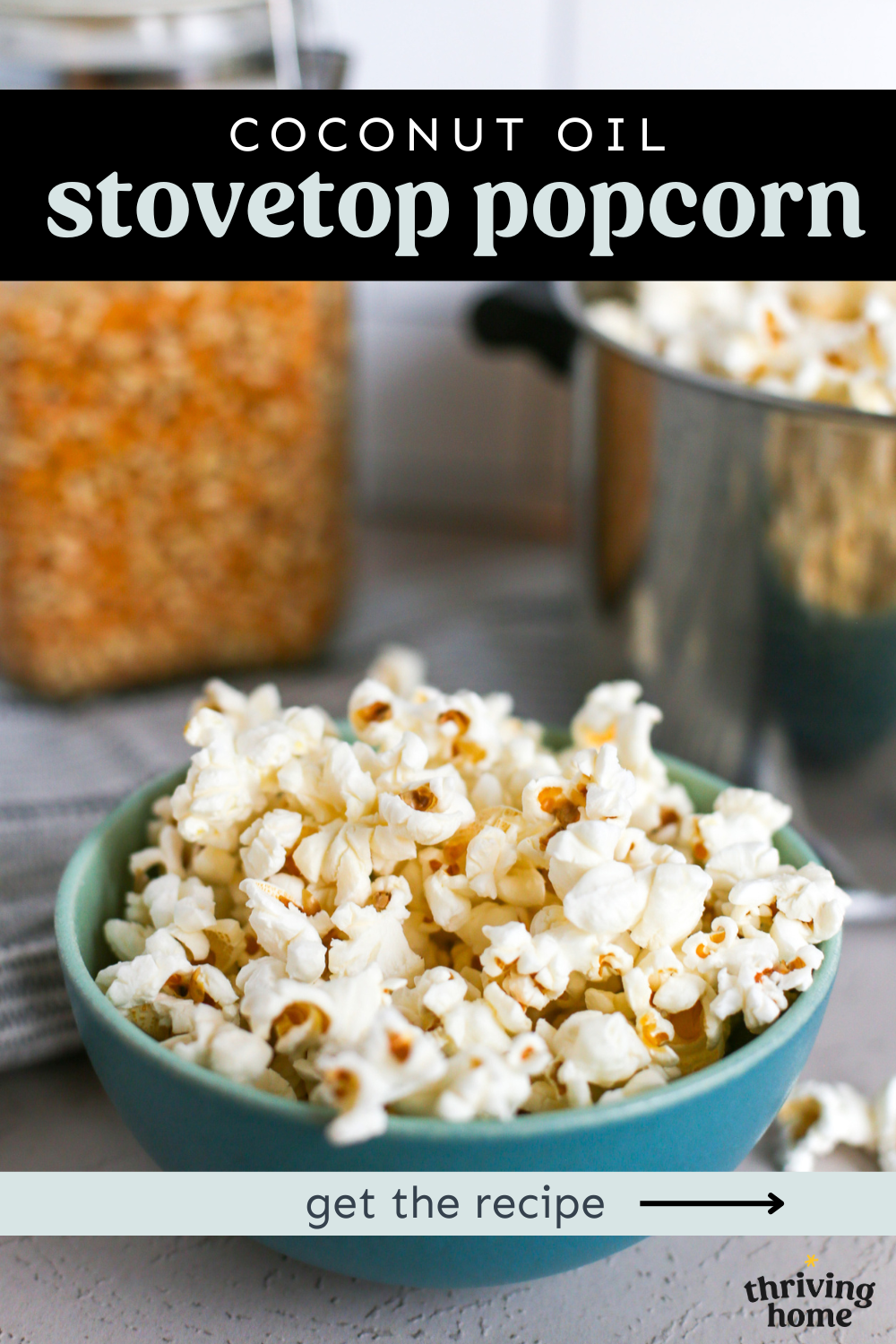 Stovetop popcorn in a blue bowl with the full pot of popcorn in the background.