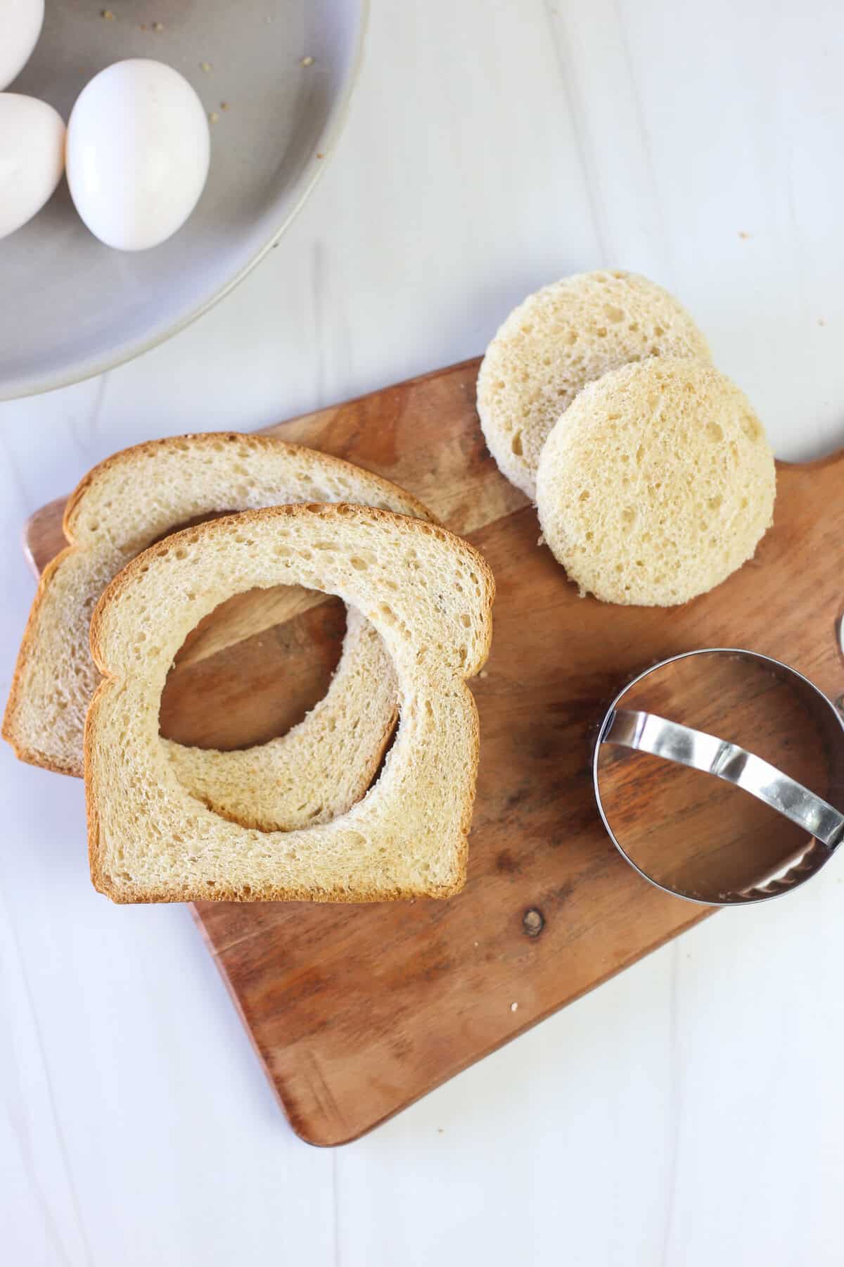 Bread with circles cut out of the center to prep for egg in a hole.