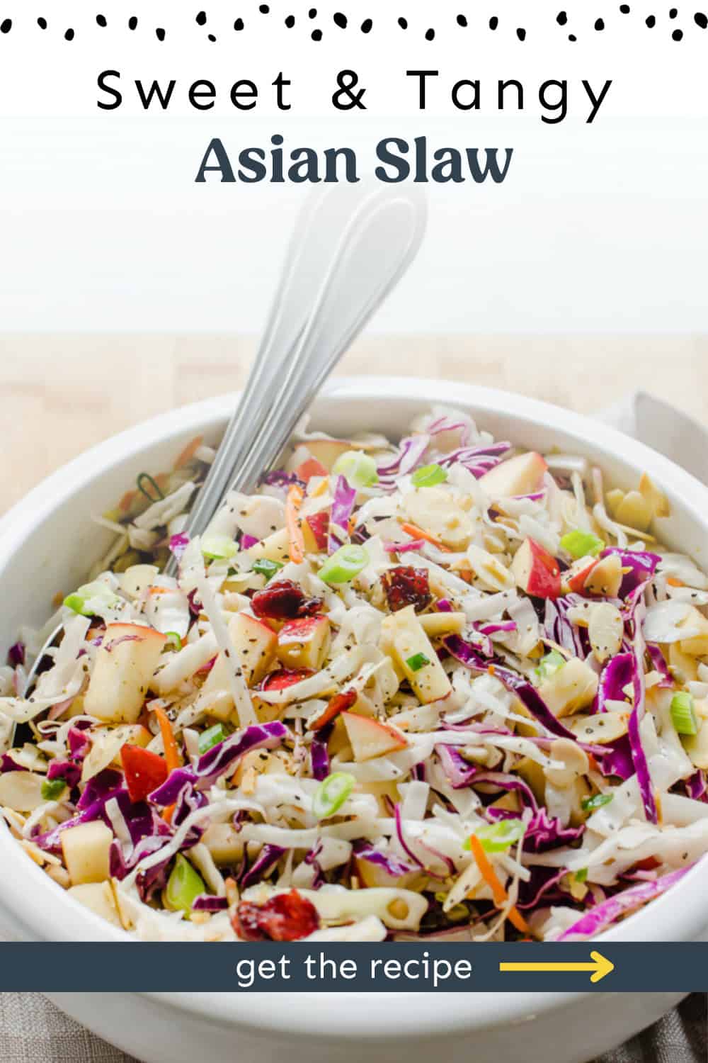 A bowl of Asian slaw with two spoons in it.
