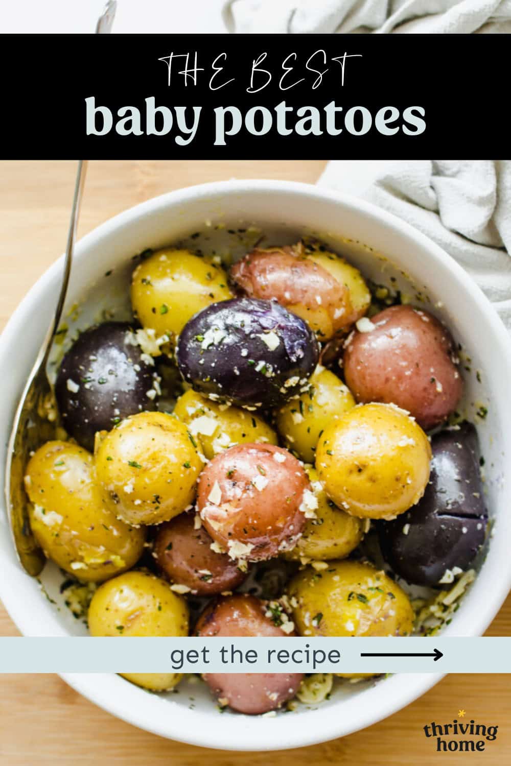 A bowl of red, yellow, and purple baby potatoes with Parmesan and parsley on them.