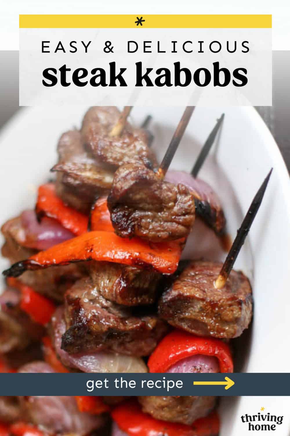 Steak kabobs stacked on a white platter.