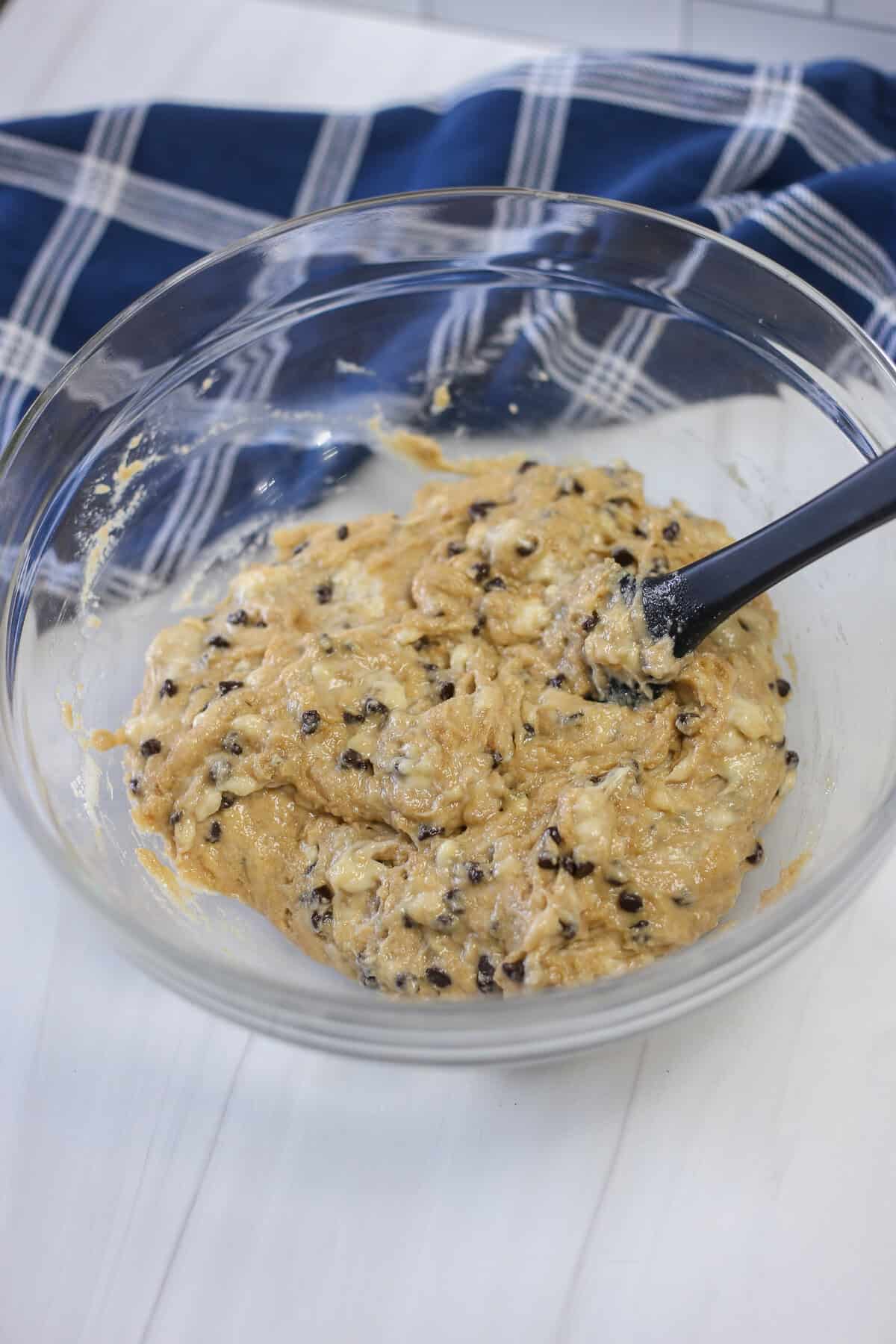 Banana chocolate chip muffin batter in a glass bowl.