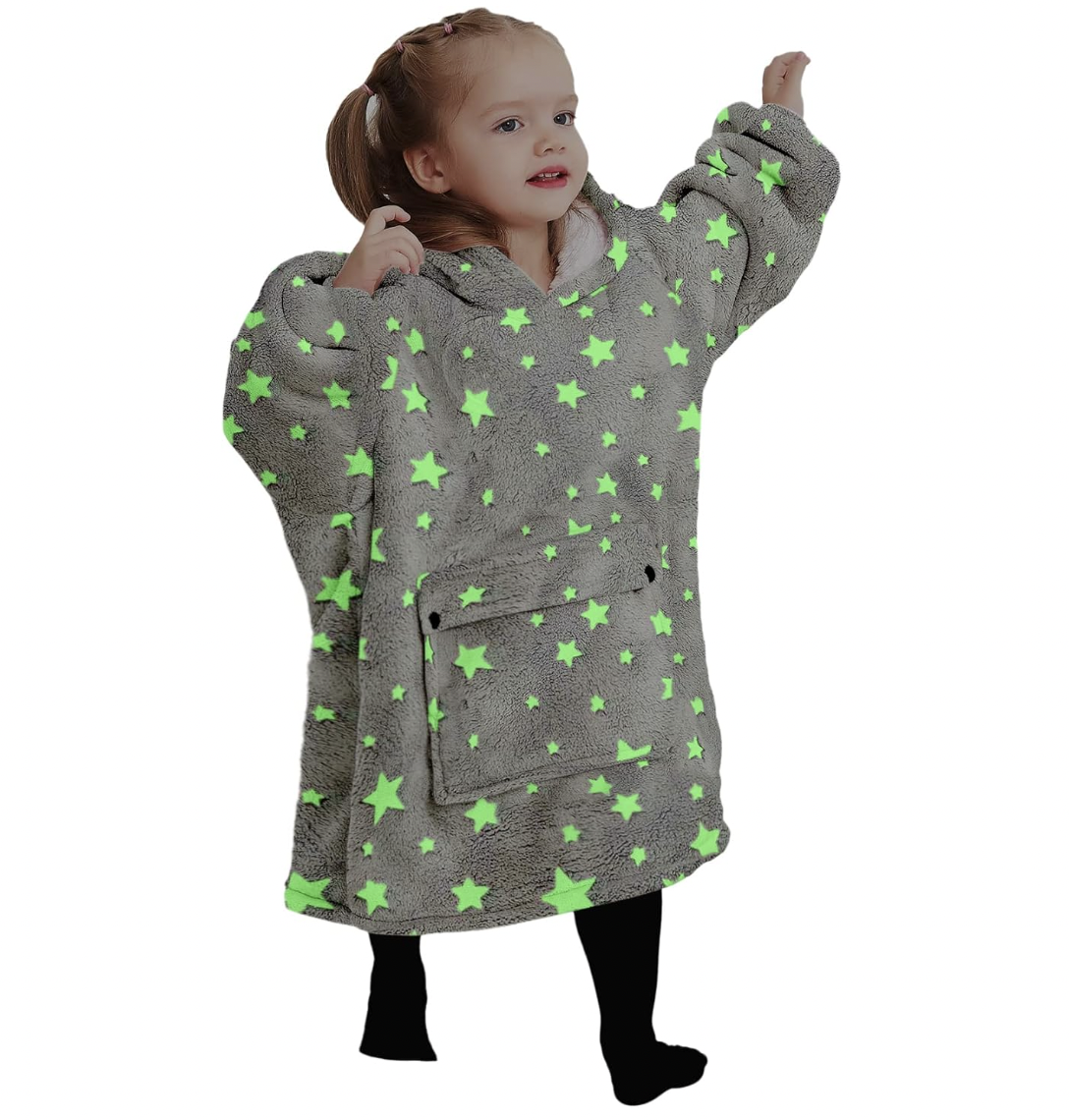 A young girl wearing a blanket with stars on it.