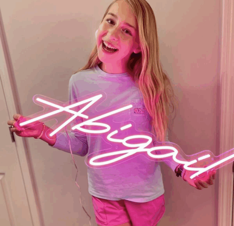 A girl holding a custom neon sign.