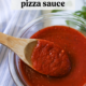 A bowl of homemade pizza sauce with a wooden spoon dipped in it.