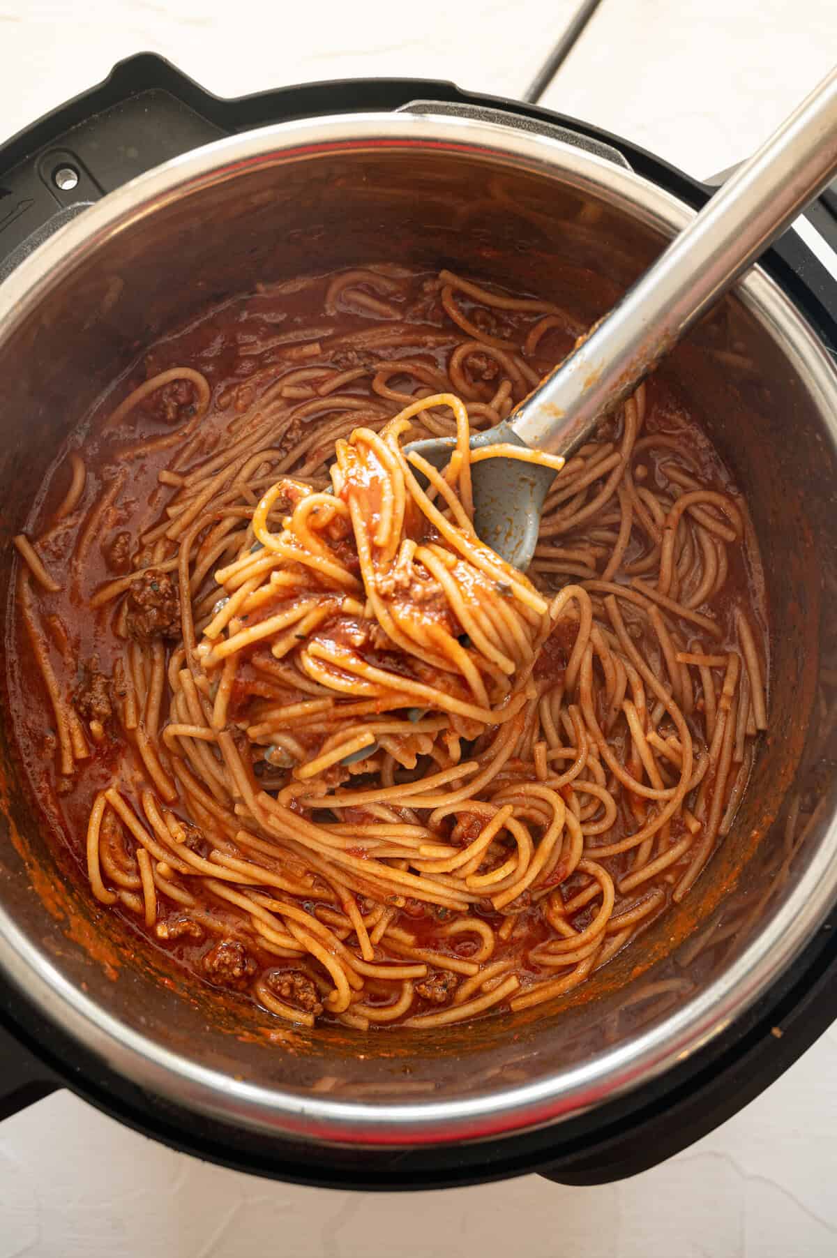Instant Pot spaghetti with meat being served straight from the Instant Pot.