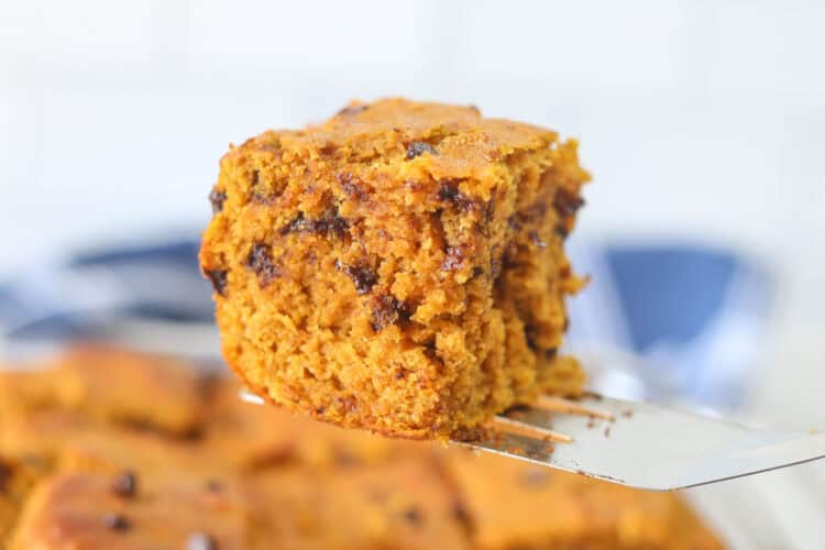 A slice of banana cake being lifted on a spatula from a baking dish.