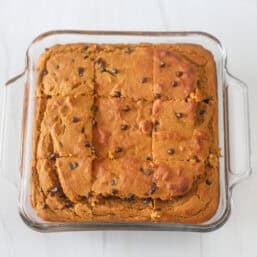 Banana breakfast cake cut into 9 pieces in a square baking dish.