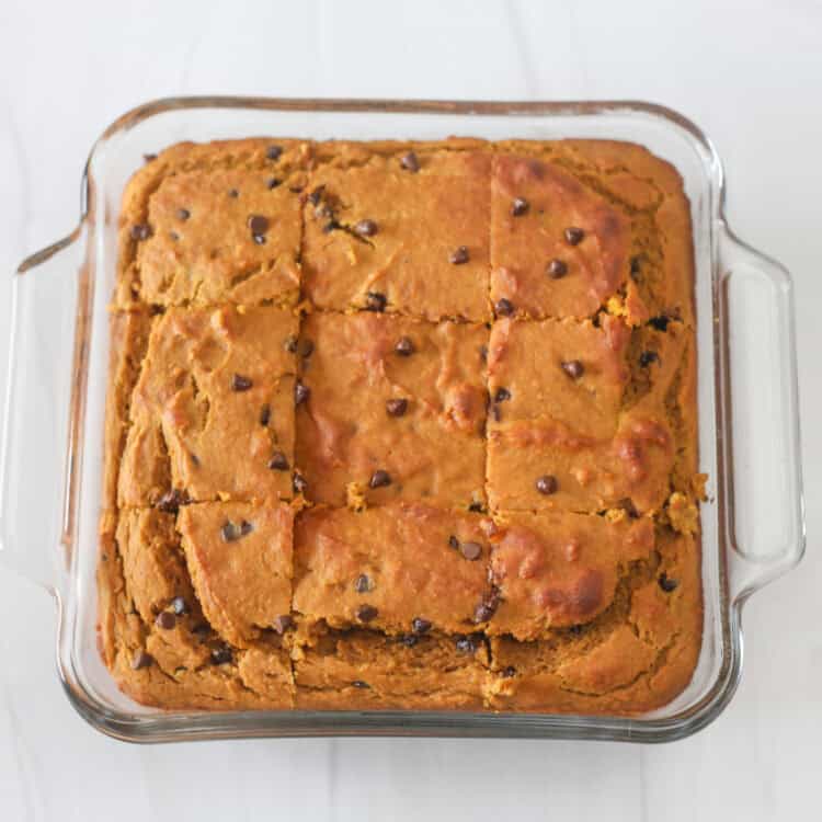 Banana breakfast cake cut into 9 pieces in a square baking dish.