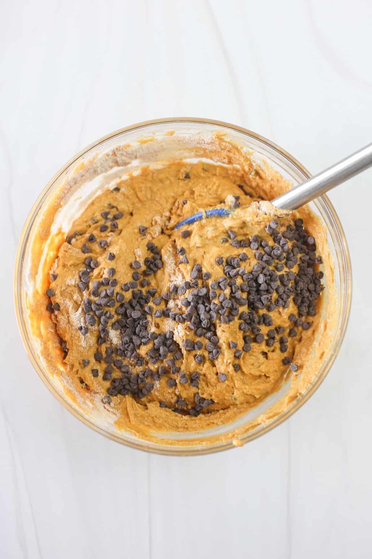 Chocolate chips being mixed into banana breakfast cake batter.