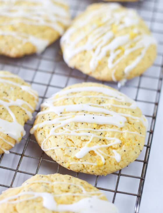 Lemon poppyseed cake mix cookies on a baking rack with glaze drizzled on top.