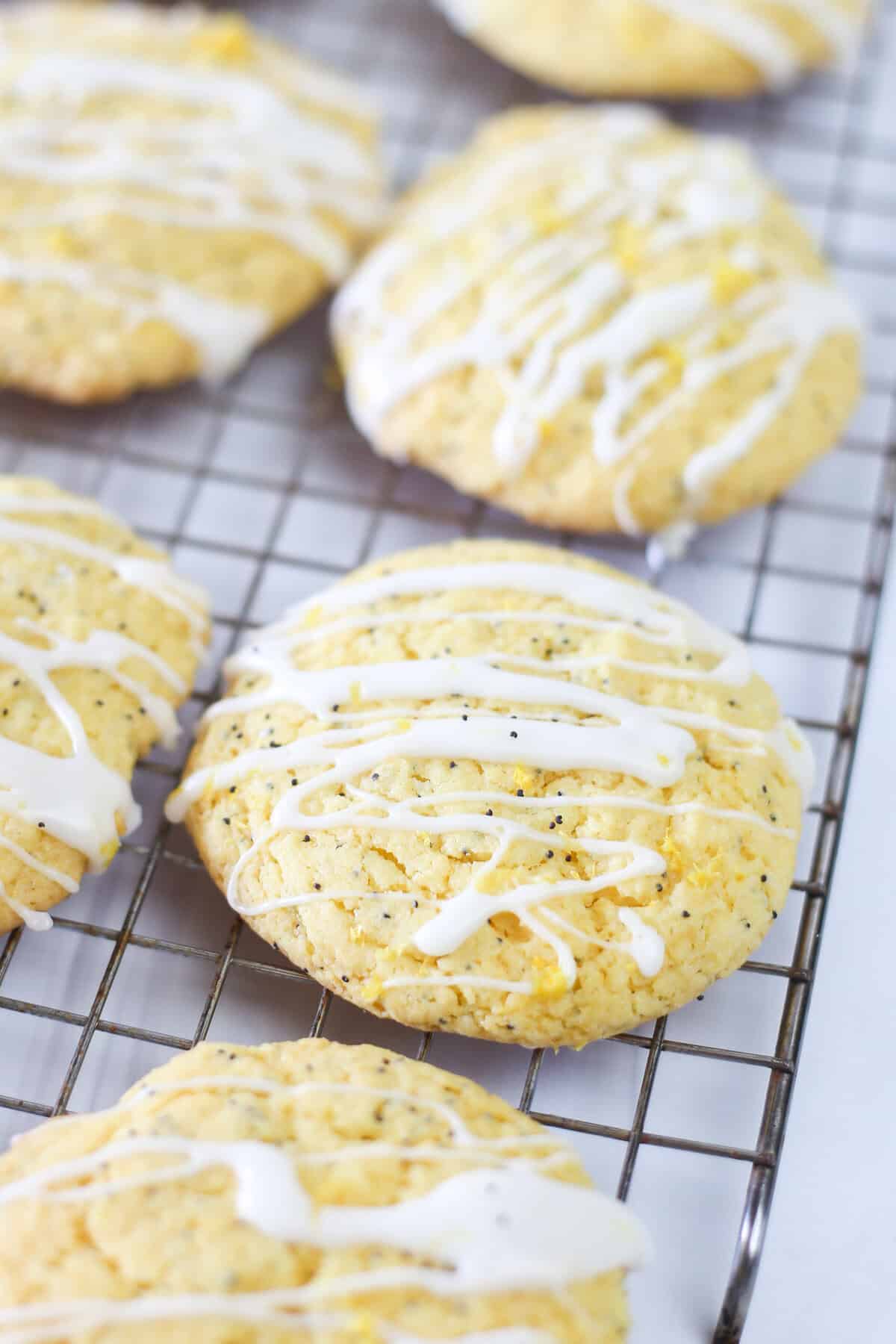 Lemon poppyseed cake mix cookies on a baking rack with glaze drizzled on top.