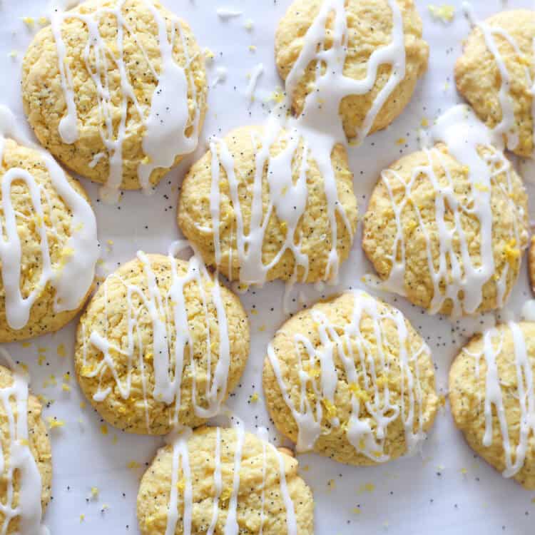 Lemon poppyseed cake mix cookies lined up on parchment paper drizzled with glaze.