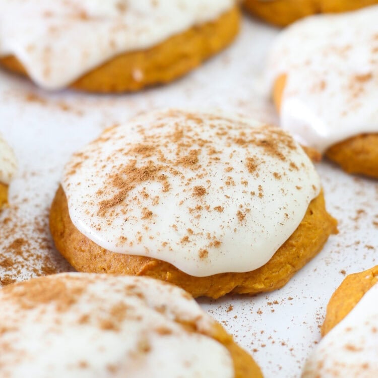 Pumpkin spice cake mix cookies with icing and sprinkled cinnamon on top.