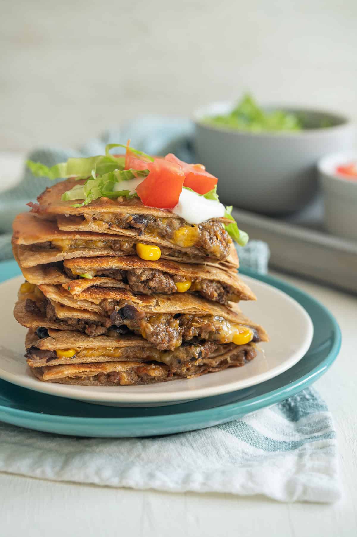 Ground beef quesadilla quarters stacked up on a plate.