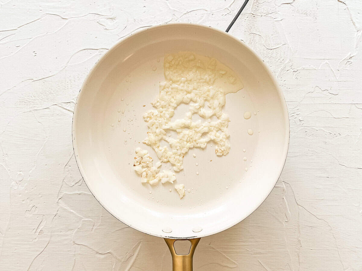 Diced onion sauteing in a skillet.