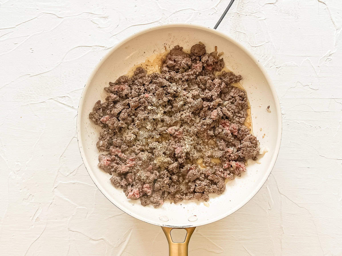 A skillet with ground beef browning.