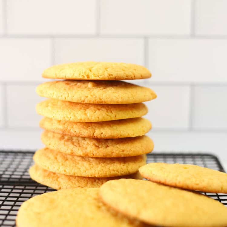 Cake mix cookies stacked up on a baking rack.