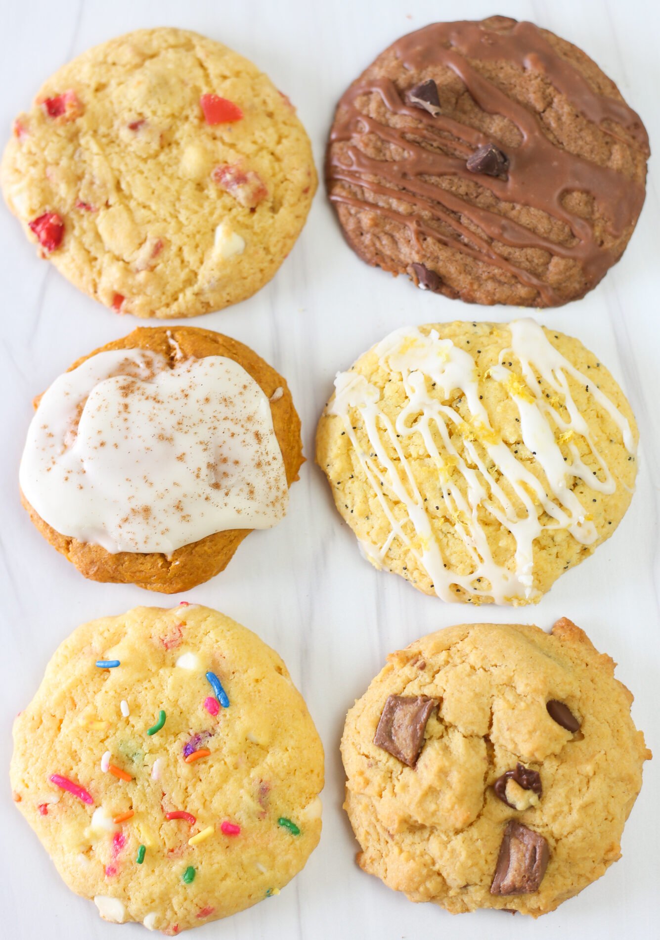 One each of six different cake mix cookie flavors lined up: strawberries and cream, Nutella, pumpkin spice, lemon poppyseed, Funfetti, and peanut butter cup.