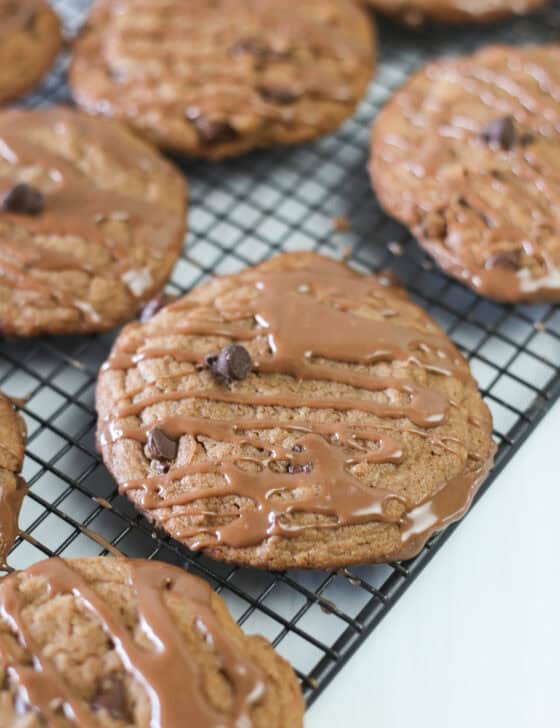 Nutella cake mix cookies on a baking rack with Nutella glaze drizzled on top.