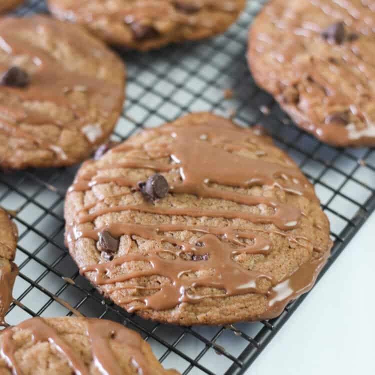 Nutella cake mix cookies on a baking rack with Nutella glaze drizzled on top.