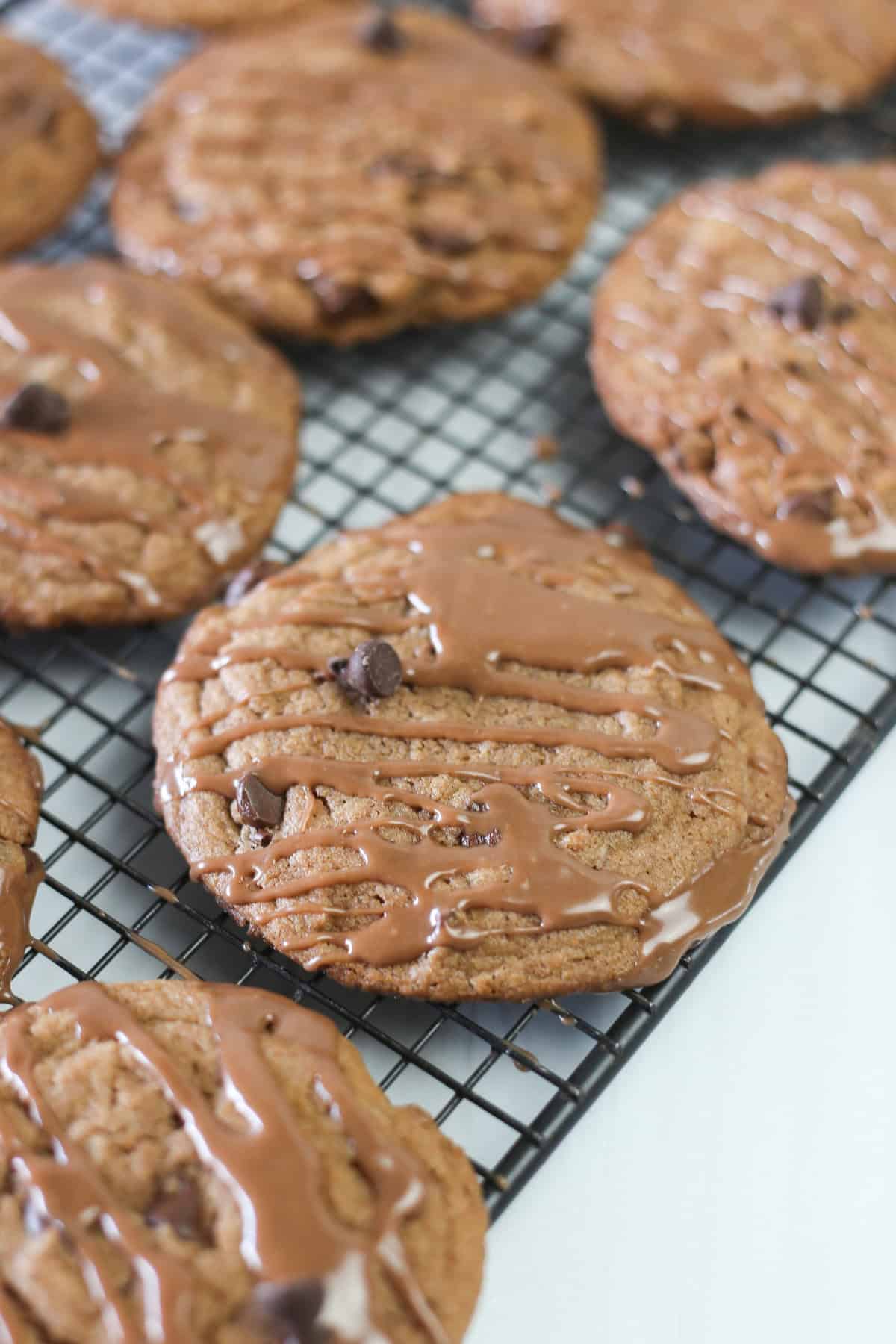 Nutella cake mix cookies on a baking rack with Nutella glaze drizzled on top.