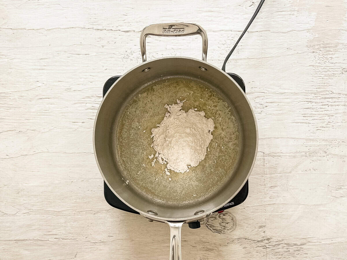 Flour dumped on top of melted butter in a sauce pan to make a roux.