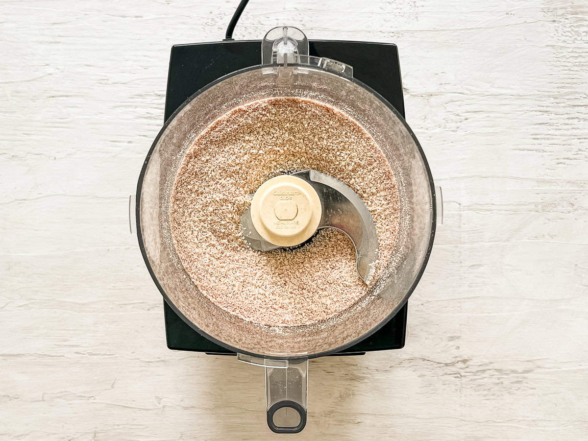 Processed breadcrumbs with spices in a food processor bowl.