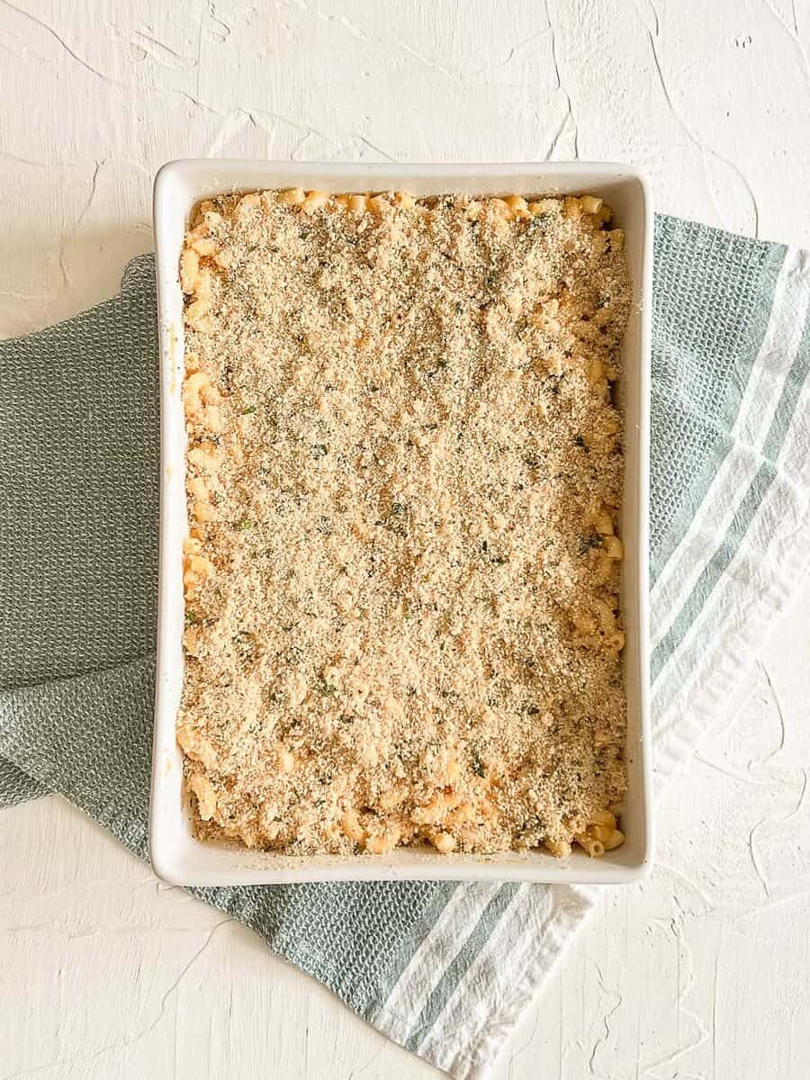 A 9x12 baking dish with breadcrumbs on top of mac and cheese ready to be baked.