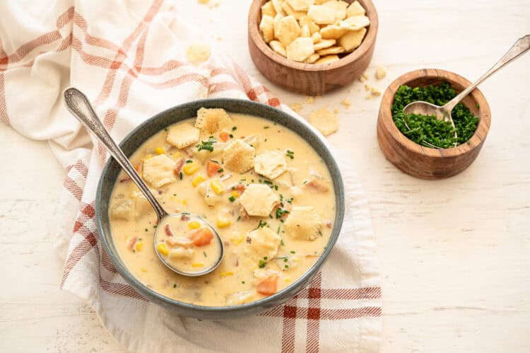 A bowl of Autumn Chowder with potatoes, corn, carrots, and cheese.