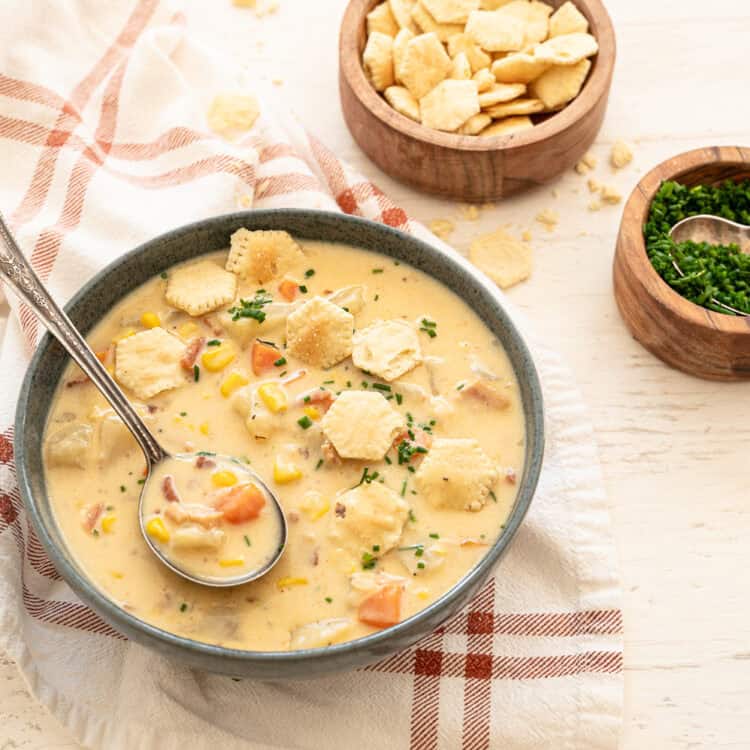 A bowl of Autumn Chowder with potatoes, corn, carrots, and cheese.