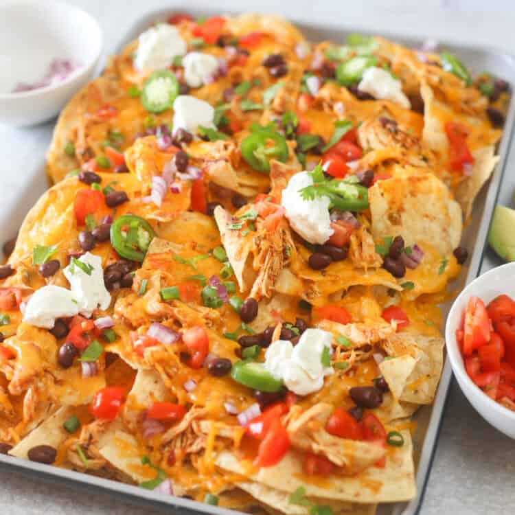 Shredded chicken nachos on a baking sheet.