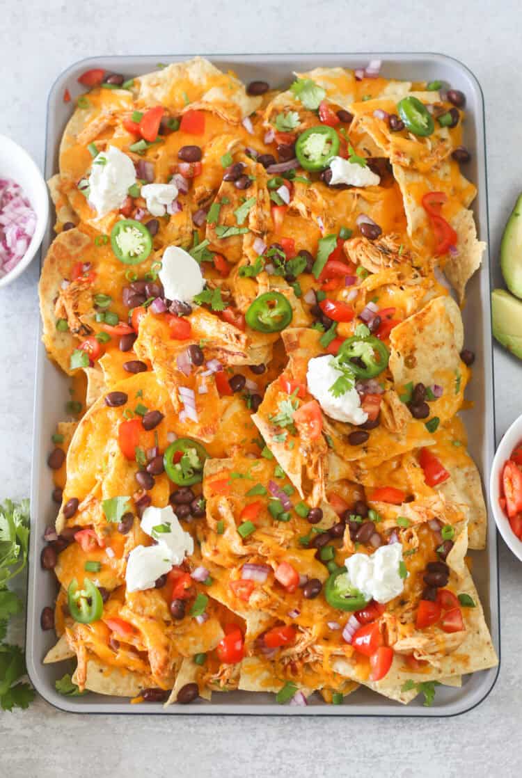 A sheet pan full of shredded chicken nachos.
